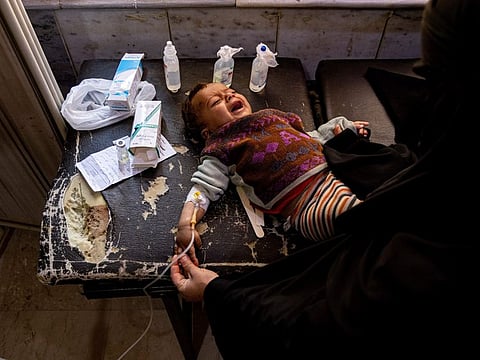 Mother holds her child diagnosed with cholera in a hospital in Deir Al Zour, Syria.  