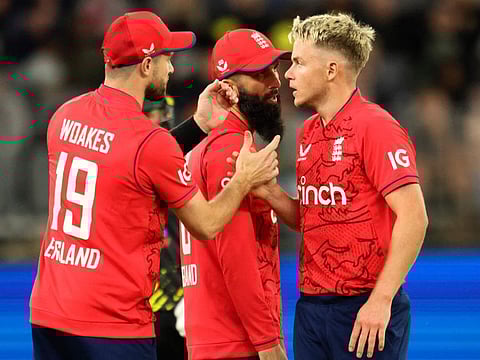 England's Chris Woakes (left) and Moeen Ali of England talk with Sam Curran during the first match of the Twenty20 series against Australia at Optus Stadium in Perth.