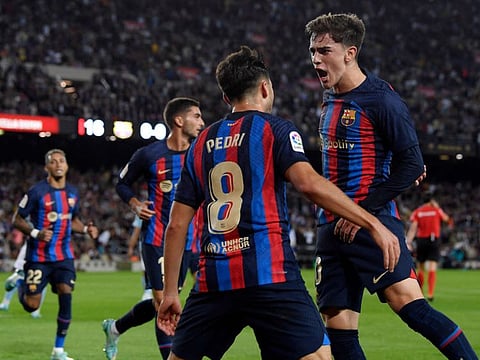 Barcelona's midfielder Pedri (centre) celebrates scoring the opening goal with Gavi (right) during the Spanish League match against RC Celta de Vigo at the Camp Nou stadium in Barcelona.