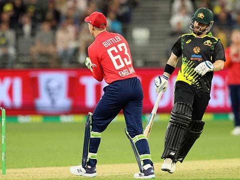 Australia's Matthew Wade (right) runs between the wickets past England's wicketkeeper Jos Buttler (left) during the first Twenty20 at Optus Stadium in Perth on Sunday.
