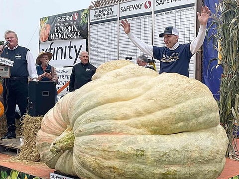 Travis Gienger from Anoka, stands behind his winning pumpkin at the 49th World Championship Pumpkin Weigh-Off in Half Moon Bay, California. 