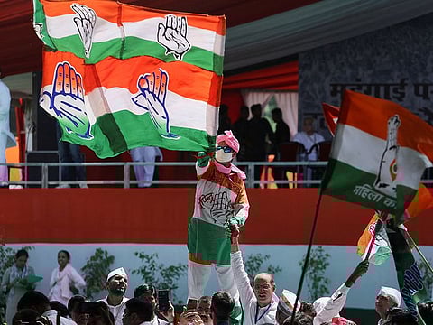 A supporter waves a flag of India's main opposition Congress party in New Delhi, India.