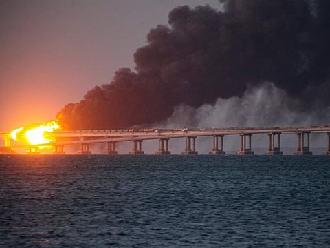 Flame and smoke rise from the Crimean Bridge connecting Russian mainland and the Crimean peninsula over the Kerch Strait, in Kerch, Crimea, Oct. 8, 2022.