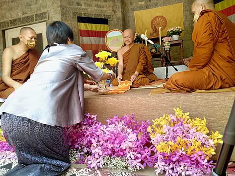 A devotee presenting a gift to the Sangha at the end of his three-month rain retreat in Taxila on Wednesday.