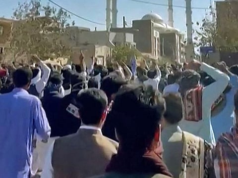  This image grab from a UGC video made available on October 14, 2022, shows Iranian protesters chanting slogans as they march in a street in the southeastern city of Zahedan.  