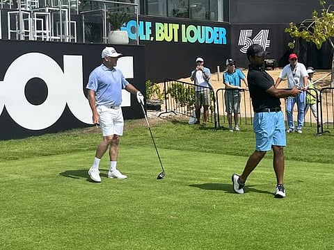 Anirban Lahiri teeing off on hole one under the watchful eye of Lee Westwood.
