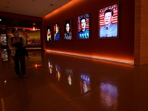A man walks past portraits of (L to R) late Chinese chairman Mao Zedong and former Chinese leaders Deng Xiaoping, Jiang Zemin, Hu Jintao and current president Xi Jinping at Yanan Revolutionary Memorial Hall in Yan'an city, in Chinas northwest Shaanxi province on October 15, 2022, one day ahead of the 20th Communist Party Congress.