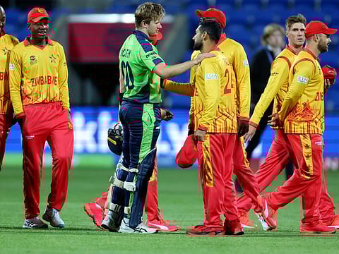 Zimbabwe players celebrate their win as Ireland's Barry McCarthy (centre) walks back to the pavilion after the ICC mens Twenty20 World Cup 2022 cricket match at Bellerive Oval in Hobart.
