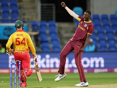 West Indies' Jason Holder celebrates after dismissing Zimbabwe's Ryan Burl (left) during the ICC mens Twenty20 World Cup 2022 at Bellerive Oval in Hobart on Wednesday.