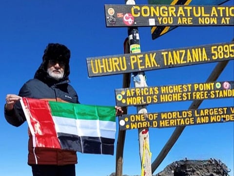 Raman Chander Sood, an Indian expat grandfather in Dubai aged 70, waving UAE flag after climbing Mount Kilimanjaro on October 15