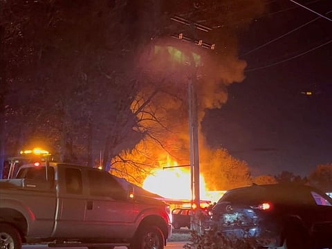 Emergency vehicles stand on the road outside of a burning building after a plane crashed into a building in Keene, New Hampshire.