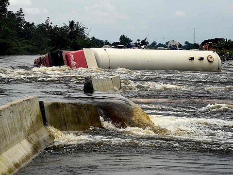 A tanker truck falls across the East-West highway severed by flooding, bringing to a halt the movement of vehicles and economic activities, in Niger delta region of Ahoada, Rivers State, southern Nigeria, on October 21, 2022.  