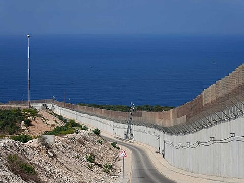 The wall on the Israeli border with Lebanon, is seen at right, with the Mediterranean Sea in the distance, in Ras Hanikra, Israel, on Oct. 14, 2022. 
