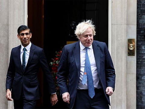   Boris Johnson and Rishi Sunak walk out of Downing Street to meet Michelle Ovens of Small Business Saturday, in London, Britain, December 1, 2021.