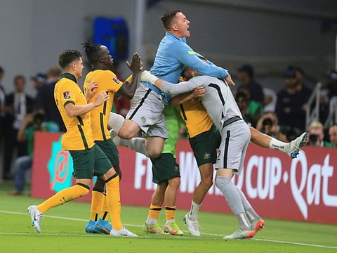 Australian players celebrate after winning in a penalty shoot-out during the World Cup 2022 qualifying play-off against Peru in Al Rayyan on June 13.