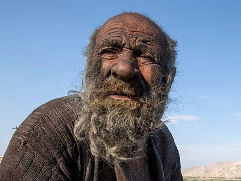 In this file photo taken on December 28, 2018 Amou Haji (uncle Haji) sits on the outskirts of the village of Dezhgah in the Dehram district of the southwestern Iranian Fars province. 