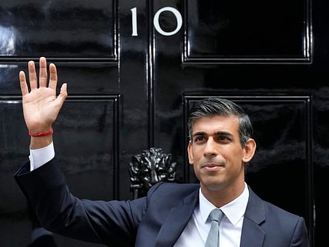 New British Prime Minister Rishi Sunak waves after arriving at Downing Street in London, Tuesday, Oct. 25, 2022, after returning from Buckingham Palace where he was formally appointed to the post by Britain's King Charles III.