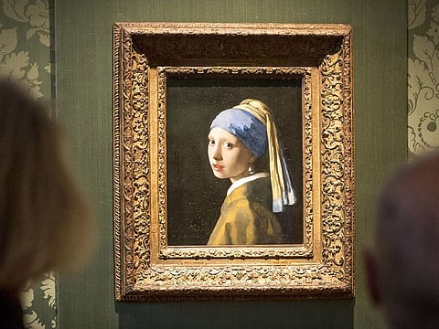 Visitors looks at the Johannes Vermeer's painting "Girl with a Pearl Earring" at the Mauritshuis museum in The Hague, 27 October 2022. 