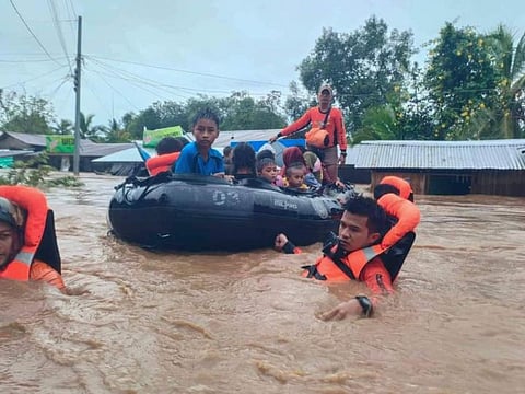 In this photo provided by the Philippine Coast Guard, rescuers use boats to evacuate residents from flooded areas due to Tropical Storm Nalgae at Parang, Maguindanao province, southern Philippines on Friday Oct. 28, 2022.  