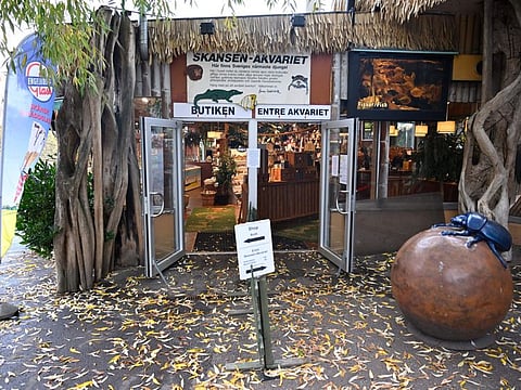 The Skansen Aquarium's entrance, part of the zoo on Djurgarden island, where a deadly snake escaped on Saturday via a light fixture in the ceiling of its glass enclosure, in Stockholm, Sweden, Monday Oct. 24, 2022.