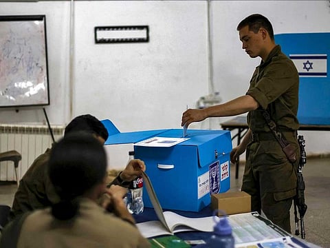 An Israeli soldier casts a ballot a day early in the Israeli general elections at a military base of Har Dov on Mount Hermon, a strategic and fortified outpost at the crossroads between Israel, Lebanon, and Syria, in the Israeli-annexed Golan Heights on October 31, 2022. 