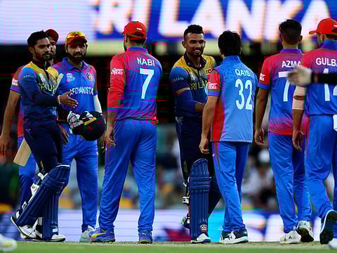Sri Lanka's Captain Dasun Shanaka (left) and Dhananjaya de Silva (centre) shake hands with Aghanistan players after their win during the ICC men's Twenty20 World Cup 2022 cricket at The Gabba.
