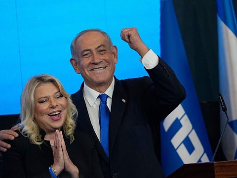 Former Israeli Prime Minister and the head of Likud party, Benjamin Netanyahu and his wife Sara gesture after first exit poll results for the Israeli Parliamentary election at his party's headquarters in Jerusalem, on November 2, 2022. 