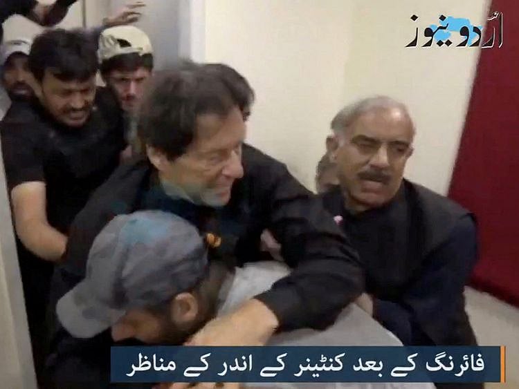 Former Pakistani Prime Minister Imran Khan is helped after he was shot in the shin in Wazirabad in this still image obtained from video.  