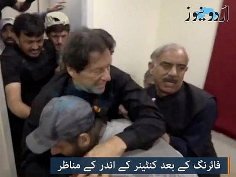 Former Pakistani Prime Minister Imran Khan is helped after he was shot in the shin in Wazirabad in this still image obtained from video.  