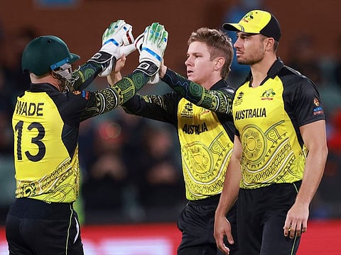 Australia’s Matthew Wade (left) congratulates Adam Zampa after taking the wicket of Afghanistan’s Ibrahim Zadran during the T20 World Cup cricket match against Afghanistan in Adelaide, Australia, on November 4, 2022. 