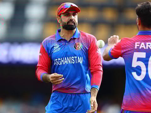 Mohammad Nabi (left) hands over the ball to Fareed Ahmad Malik. 