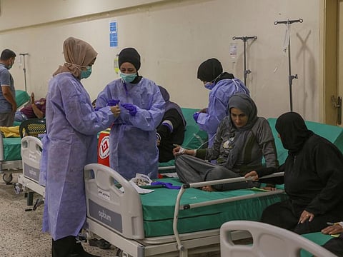 Health workers attend to suspected cholera patients inside a field hospital in Bebnine, Akkar district, northern Lebanon.