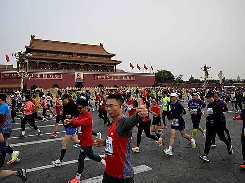 Participants run past Tiananmen Square during the Beijing Marathon in the Chinese capital.
