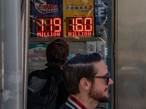 A person looks at a digital billboard advertising Powerball’s Jackpot of 1.6 billion dollars in New York City on November 4, 2022