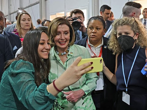 A woman snaps a 'selfie' picture with US House Speaker Nancy Pelosi, after participating in a discussion session at the Sharm Al Sheikh International Convention Centre on November 10, 2022. 