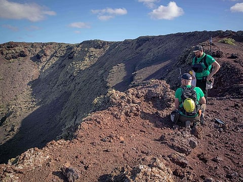 German astronaut Alexander Gerst (R) work on the summit of an ancient volcano during a training program in Lanzarote to learn how to explore the Moon and Mars in the Timanfaya National Park.