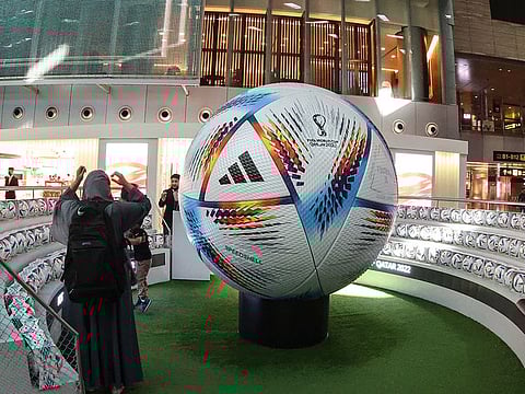 A traveller stands next to a giant football in the new central concourse building at the Hamad International Airport in the Qatari capital Doha.