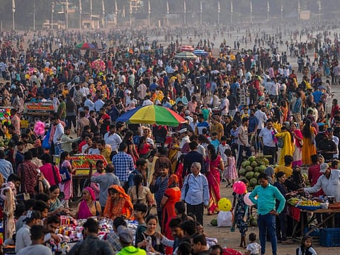 People crowd at the Juhu beach on the Arabian Sea coast in Mumbai, India, on  November 13, 2022. The 8 billionth baby on Earth was born on a planet that is getting hotter. But experts in climate science and population both say the two issues aren't quite as connected as they seem.  