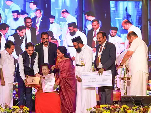 Indian Ambassador to the UAE Sunjay Sudhir and church officials present the Unsung Hero Award to Kanmony S in Dubai.