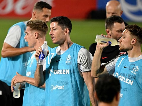 Poland's forward Robert Lewandowski (centre) and teammates drink during a training session at the Al Kharaitiyat SC in Doha.