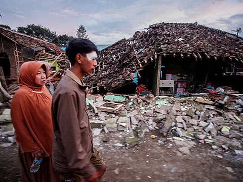 Locals walk past collapsed houses, after earthquake hit in Cianjur, West Java province, Indonesia, on November 21, 2022. 