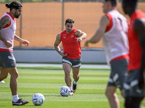 Switzerland's midfielder Xherdan Shaqiri (centre) and Switzerland's defender Ricardo Rodriguez (left) take part in a training session at the University of Doha for Science and Technology training facilities in Doha.