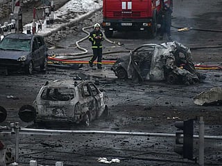 Emergency personnel walk near burnt out cars at the scene of a shelling in Kyiv, Ukraine, Wednesday. File photo taken on Nov. 23, 2022.