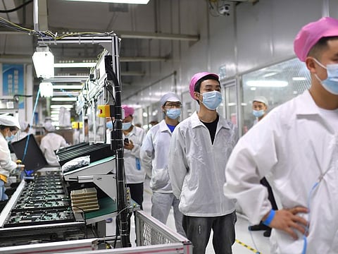 Workers line up to get tested for COVID-19 at the Foxconn factory in Wuhan in central China's Hubei province on Aug. 5, 2021.