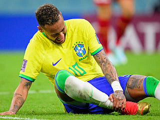 Brazil's Neymar grabs his ankle after an injury during the World Cup Group G match against Serbia.