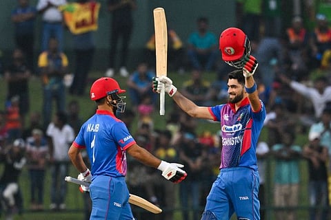 Afghanistan's Ibrahim Zadran celebrates after scoring a century with Najibullah Zadran (left) during the first One Day International in Kandy.
