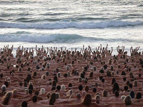 People stand near the ocean as part of artist Spencer Tunick's art installation to raise awareness of skin cancer and encourage people to have their skin checked, at Bondi Beach in Sydney, Australia, November 26, 2022.  