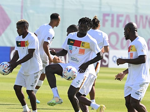Cameroon's Jerome Ngom Mbekeli (left) and Olivier Mbaizo (centre) take part in a training session at the Al Sailiya SC in Doha.