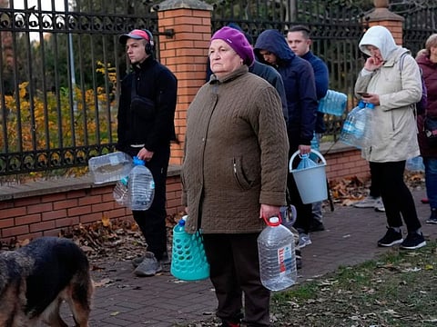 People stand in line to fill containers with water from public water pumps in Kyiv, Ukraine, Oct. 31, 2022.