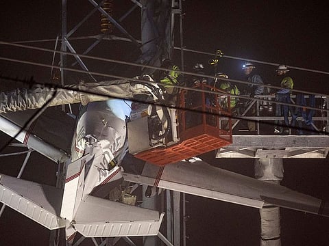 First responders work to rescue aircraft passengers after the small plane crashed and became stuck in live power lines.